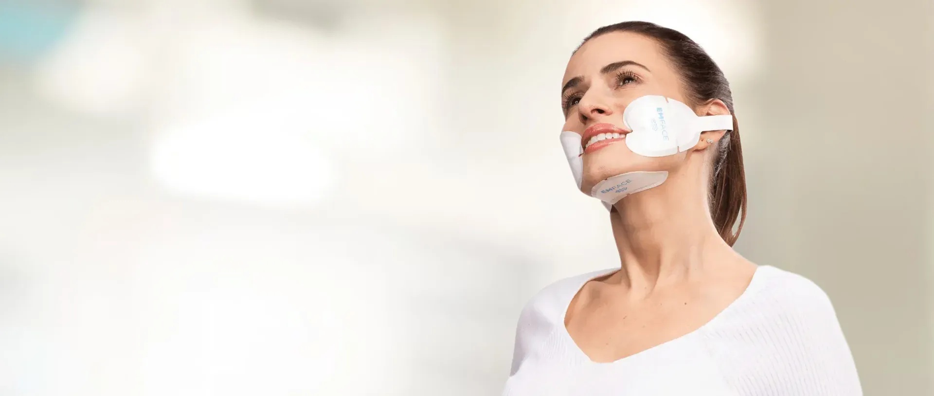 Client receiving an EMFACE treatment with facial applicators