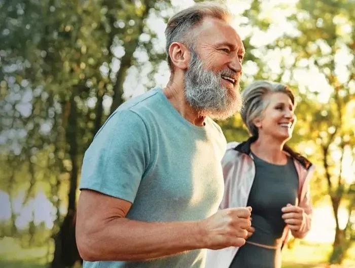 Active mature couple jogging outdoors — Emsculpt Neo for functional wellness