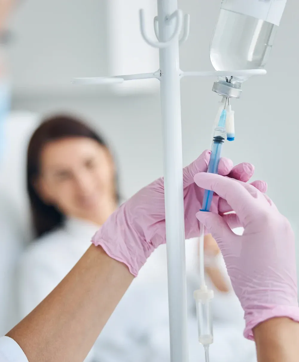 Patient receiving IV therapy as a clinician administers the infusion — Ideal Medical, Aventura